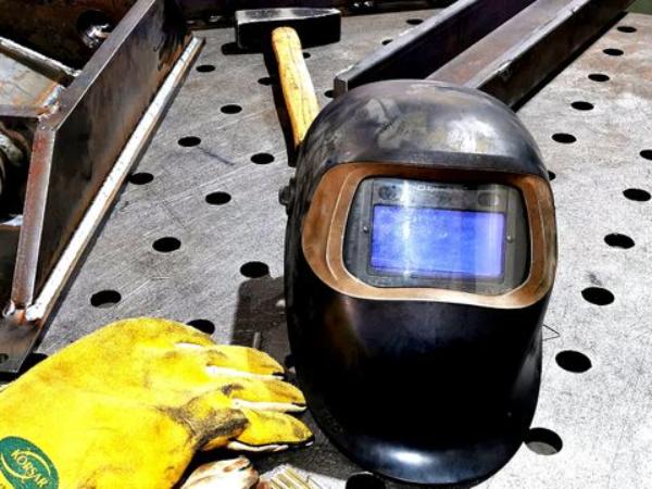 Schweißhelm und Handschuhe auf Tisch